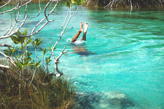 Man diving into turquoise water of seven coloured lagoon, Bacalar, Quintna Roo, Mexcico