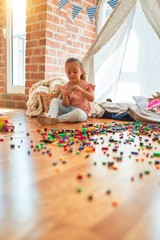 Beautiful blond toddler girl playing with constuction blocks outside tipi at kindergarten © Krakenimages.com