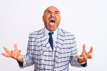 Middle age businessman wearing suit standing over isolated white background crazy and mad shouting and yelling with aggressive expression and arms raised. Frustration concept.