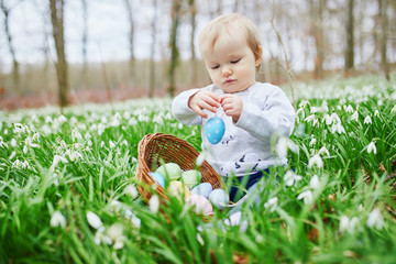 Cute little one year old girl playing egg hunt on Easter