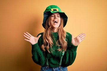 Beautiful brunette woman wearing green hat with clover celebrating saint patricks day celebrating...