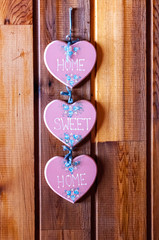 heart-shaped woden ornament on a rustic wooden cabin wall