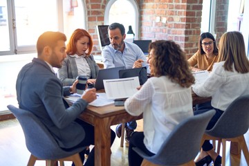 Group of business workers working together. Sitting on desk using laptop reading documents at the office