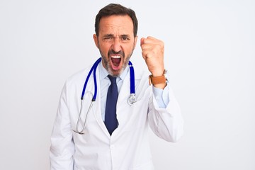 Middle age doctor man wearing coat and stethoscope standing over isolated white background angry and mad raising fist frustrated and furious while shouting with anger. Rage and aggressive concept.