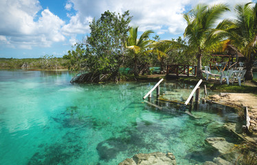 Stairs into seven colored lagoon surrounded by tropical plants in Bacalar, Quintana Roo, Mexico © Loes Kieboom