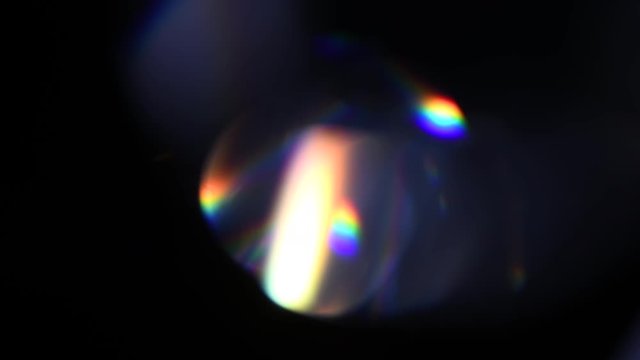 Lens Flare, Abstract Bokeh Lights Moving. Leaking Reflection of a Glass, Crystal, Defocused Shining Colorful rainbow Light Leaks, Rays on Black Background. 4K UHD video, slow motion
