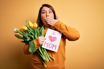 Young beautiful plus size woman celebrating mothers day holding love mom message cover mouth with hand shocked with shame for mistake, expression of fear, scared in silence, secret concept