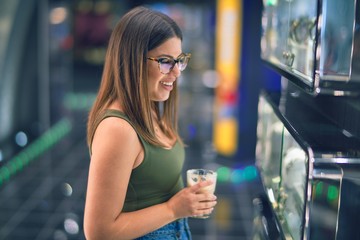 Young beautiful woman on vacation smiling happy and confident. Standing on a deck of ship with smile on drinking coffee face doing a cruise