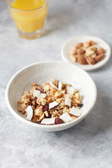 Bowl of granola with nuts, cranberry and cocoanut. Concept for a tasty and healthy meal. Stone background. 