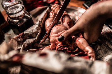 Fotografía gore de maquillaje cortando muñeco en un estudio 