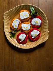 Sliced red and orange tomatoes with mozzarella, olive oil, basil