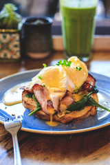 Plate of sandwich with poached egg, bacon and spinach.