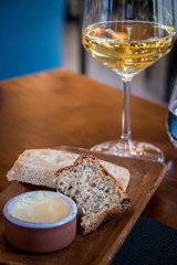 Plate of bread with butter and glass of wine.