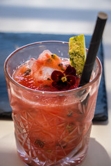 Cocktail with red fruit, fizz and straw