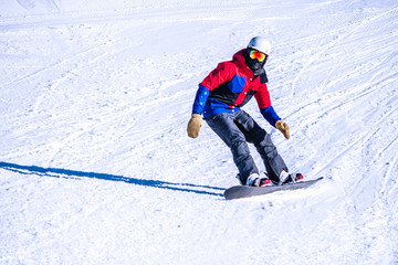 People are enjoying downhill skiing and snowboarding	