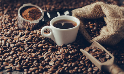 Ground coffee and coffee beans on old cafe table.