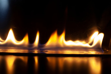 Fiery background. Flames of fire in the dark. Flame texture. Tongues of fire rise smoothly. A...