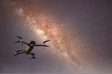 Obraz na płótnie Canvas Drone flying in starry night sky showing the galaxy and stars