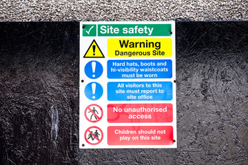 Construction site health and safety message rules sign board signage on boundary wall entrance