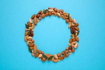 Different delicious nuts on light blue background, flat lay. Space for text