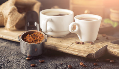 Ground coffee and coffee beans on old cafe table.