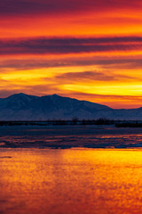 Sunrise or sunset landscape over a river with ice floating in it