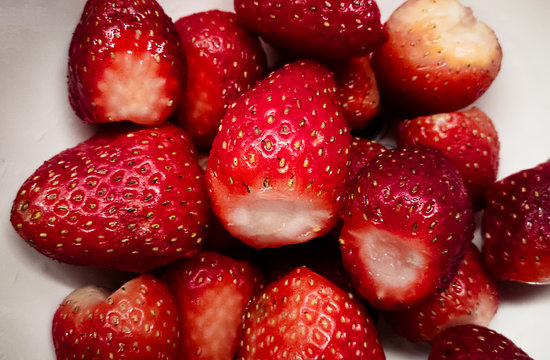 Deliciosas, frescas y rojas frutillas vistas desde un plano cenital sobre un bol blanco. 