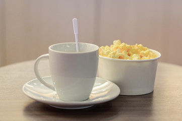 cup of coffee with milk and popcorn
