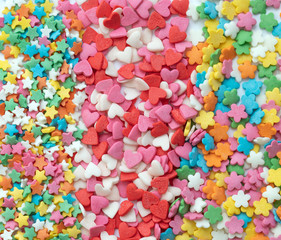 Fototapeta na wymiar Multicolored Pastry decor in the shape of hearts, Chamomiles and stars.