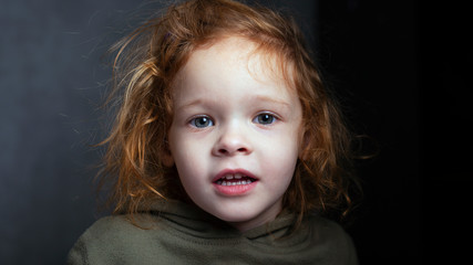pretty red-haired little girl, cute child portrait on gray background