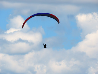 Paraglide flight in blue sky and some white clouds