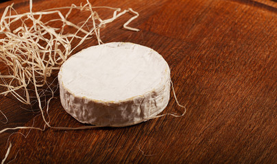 Camembert cheese or brie on wooden background