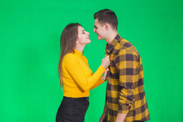 Naughty young lady is going to kiss her lover, pulling him close to her.