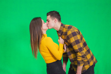 Naughty young lady is going to kiss her lover, pulling him close to her.