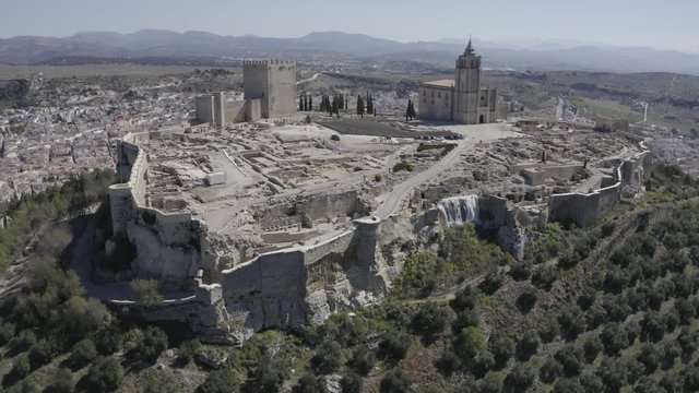 D-log aerial footage of Alcala de Real medieval fortified hilltop castle and church in Andalusia Spain