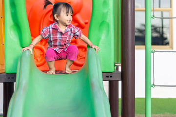 Portrait image of 1-2 yeas old baby. Happy Asian child girl smiling and laughing. She playing with slider bar toy at the playground. Learning and active of kids concept.