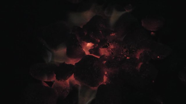 Dark top down shot of glowing barbeque charcoal briquettes