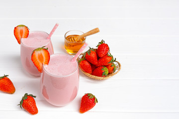 Strawberry yogurt fruit juice smoothie pink colorful fruit juice milkshake blend beverage healthy high protein the taste yummy In glass drink episode morning on white wood background.