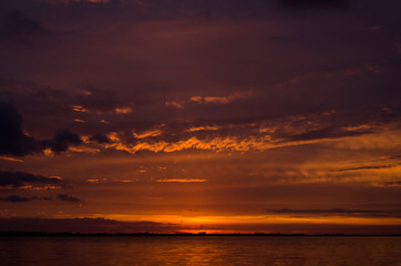 Naklejka na ściany i meble Sunset over Lake Chascomus, sky with orange clouds.