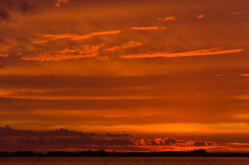 Sunset over Lake Chascomus, orange beautiful cloudy sky