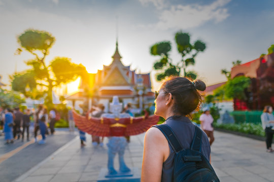 Traveler woman looking temple in Wat Arun at evening sunset time, Popular famous landmark travel Bangkok Thailand, Tourist female on holiday vacation trips, Tourism beautiful destination place Asia