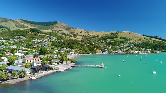 Aerial 4k forward tracking motion view of the harbour and waterfront at the historic township of Akaroa in the Canterbury shire on South Island,New Zealand