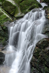 Obraz premium Waterfall with stones covered by moss in a forest (Uguisu's falls in Nara, Japan)