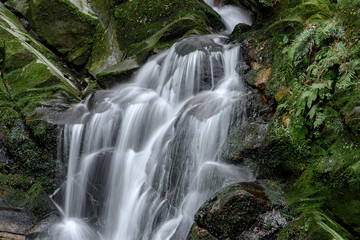 Waterfall with stones covered by moss in a forest (Uguisu's falls in Nara, Japan)