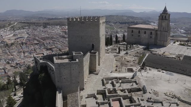 D-log aerial footage of Alcala de Real medieval fortified hilltop castle and church in Andalusia Spain