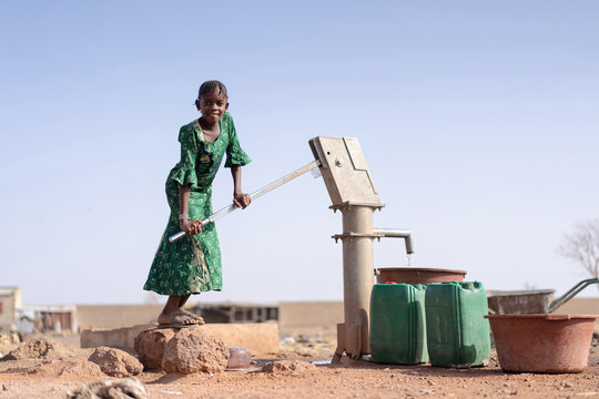 Happy Aboriginal Young Girl With Lots Of Water In A Village