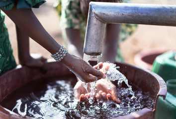 Authentic African ethnic Girl Transporting nutritious Water in a natural environment