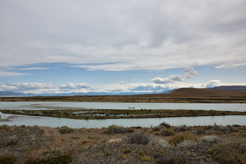 Paisaje de isla en el rio con montagnas y cielo azul con nubes de fondo