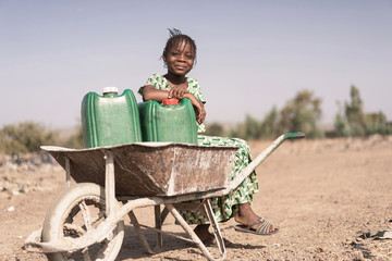 Joyful African Young Woman Transporting Natural Water for lack of water symbol