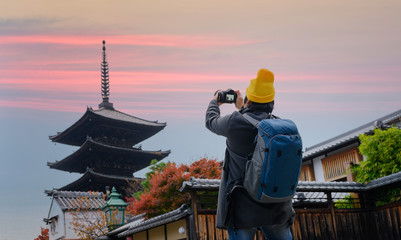 Traveller photographer in action of takes photo of the Temple in Japan village